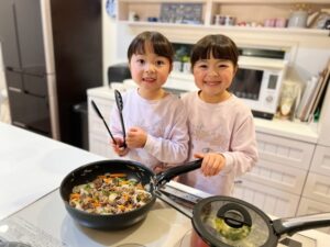 料理をする幼い姉妹、炒めれば日本酒の酒精も飛ばせる