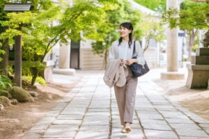 神社の境内を歩く品の良い女性