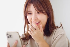 懐かしい人からの嬉しい連絡に笑顔になる女性のイメージ