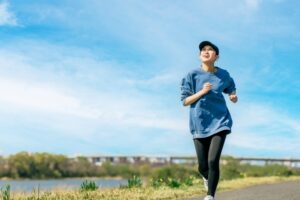 青空の下でジョギングするアクティブな女性|縁切り風水後の心構え