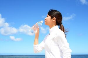 海で水を飲む女性