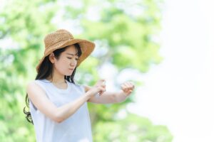虫除けスプレーする女性