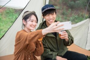 キャンプで仲良く自撮りするカップル